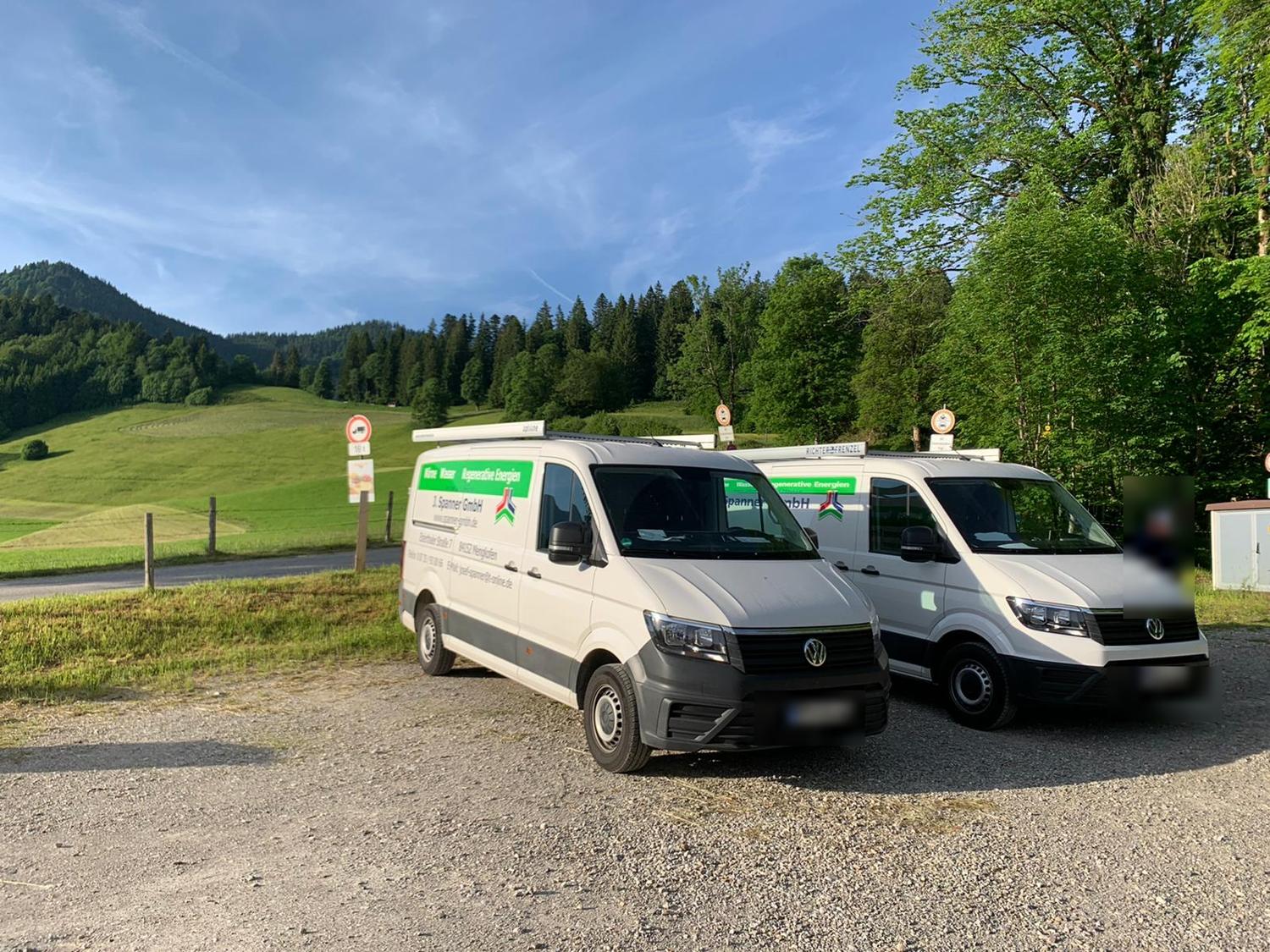 Zwei Montagefahrzeuge der J. Spanner GmbH auf einer Baustelle im Voralpenland
